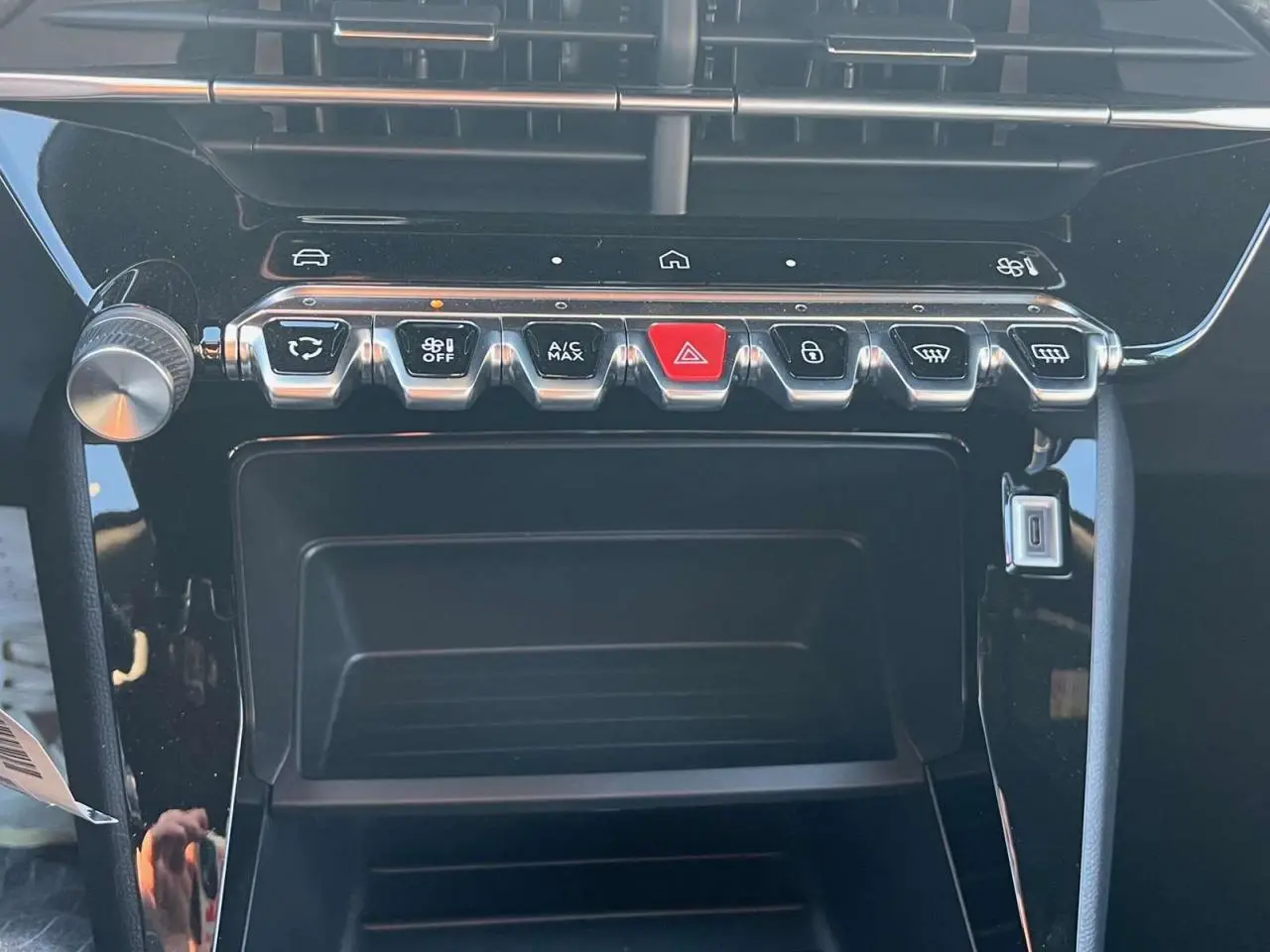 Détail de la console centrale du Peugeot 2008 2024 avec boutons de commande et finition noire brillante