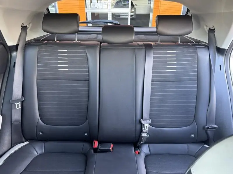 Vue arrière intérieure sur la banquette noire en cuir-tissu du Kia Stonic 2019 avec ceintures et appuie-têtes réglables.