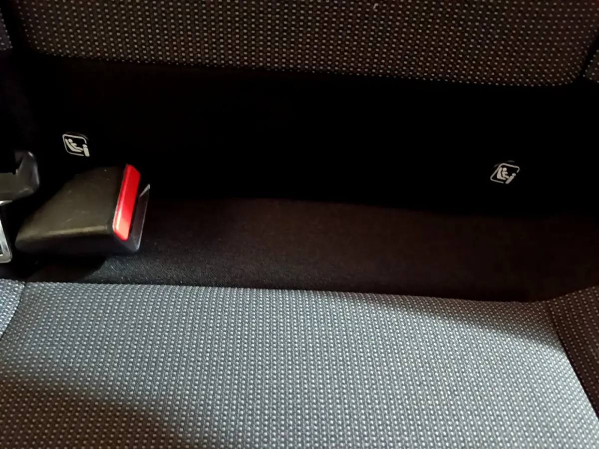 Gros plan sur la banquette arrière grise avec ceintures de sécurité et fixations Isofix visibles dans la Citroën C3 beige.