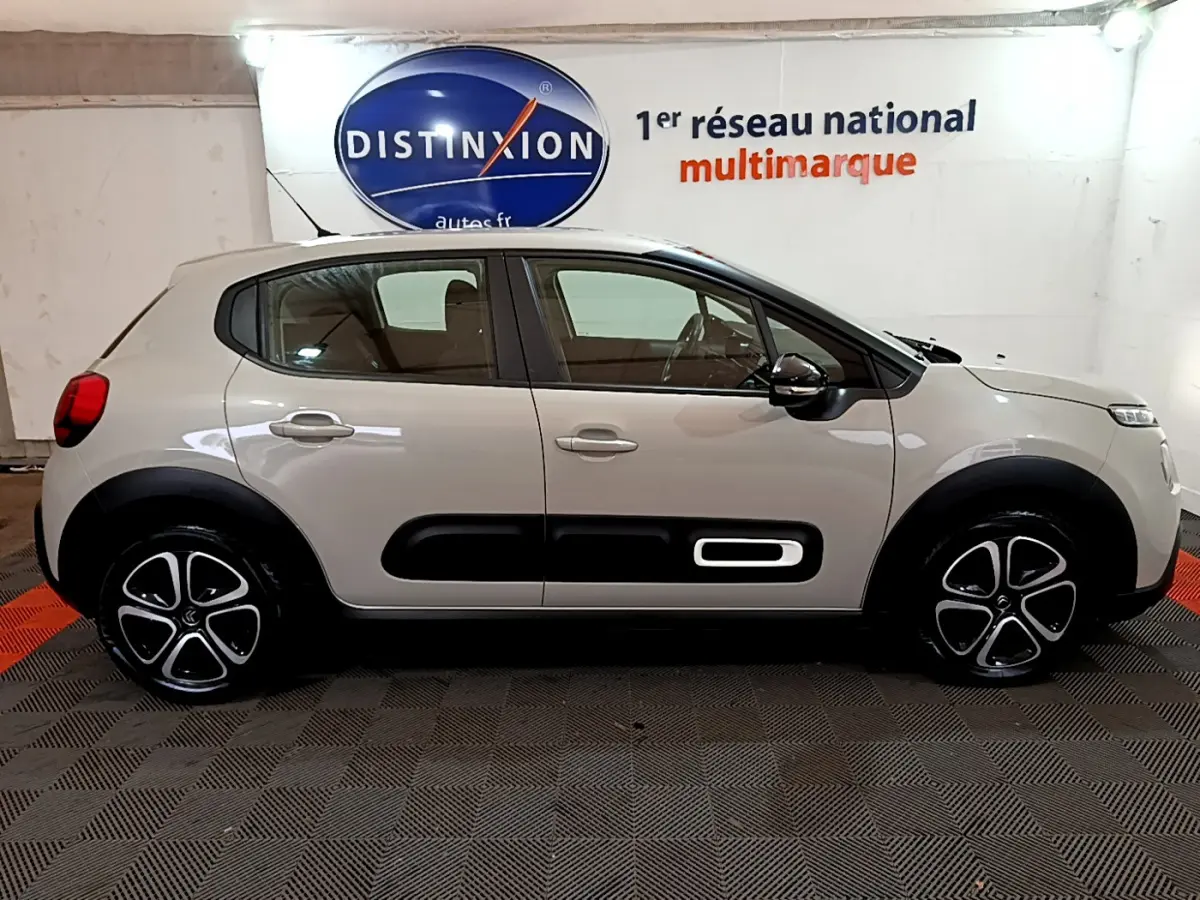 Profil côté droit d'une Citroën C3 beige 2022 avec protections latérales noires et jantes stylisées.