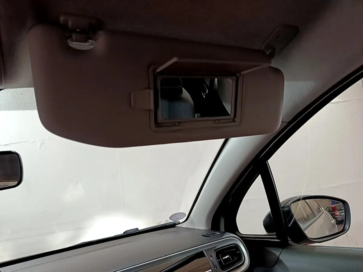 Intérieur beige de la Citroën C3 2022, vue sur pare-soleil avec miroir et rétroviseur côté droit.
