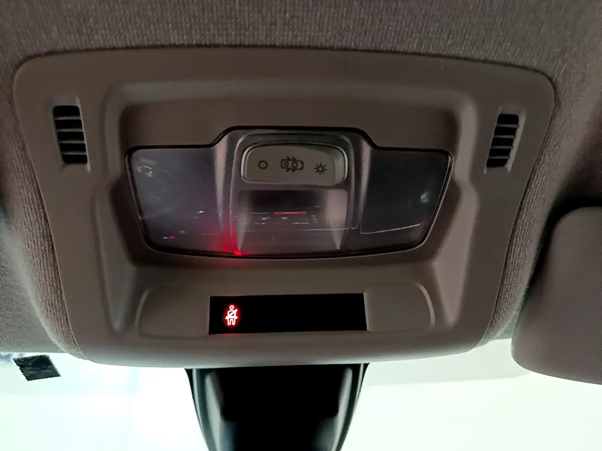 Vue intérieure du plafonnier avec éclairage et témoin de ceinture allumé dans une Citroën C3 beige 2022.