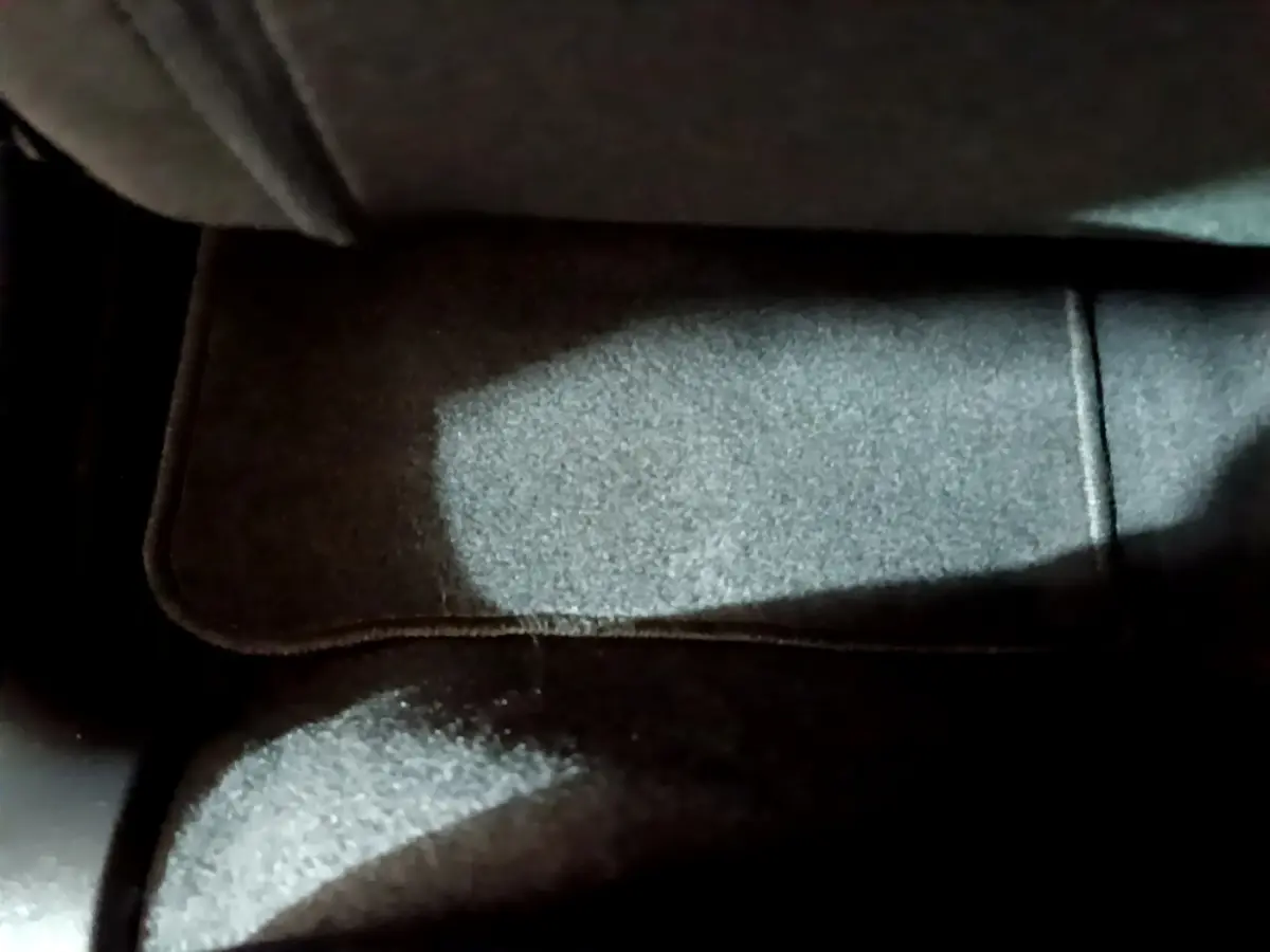 Gros plan sur le tapis de sol gris foncé à l'avant d'une Citroën C3 beige PureTech 2022