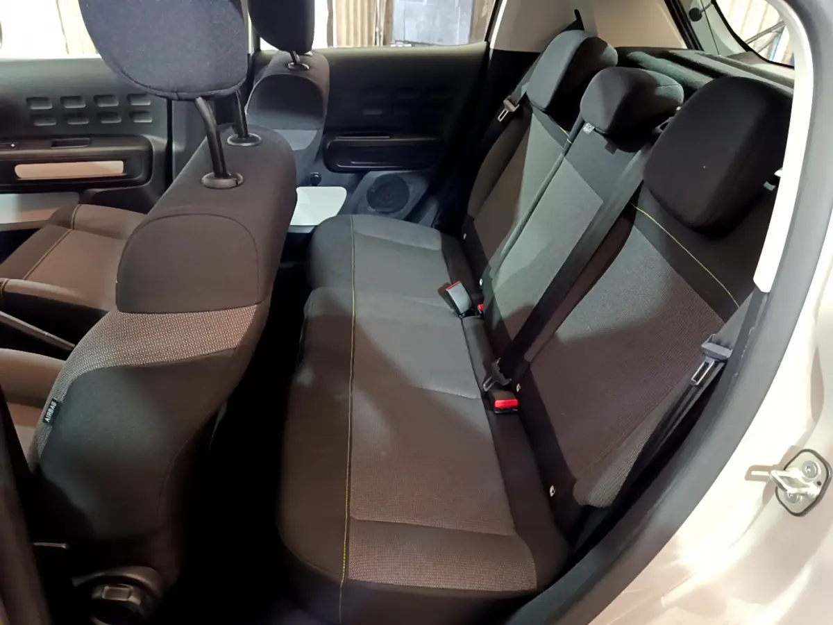 Vue intérieure côté droit sur la banquette arrière noire et grise de la Citroën C3 beige 2022 avec appuie-têtes réglables.