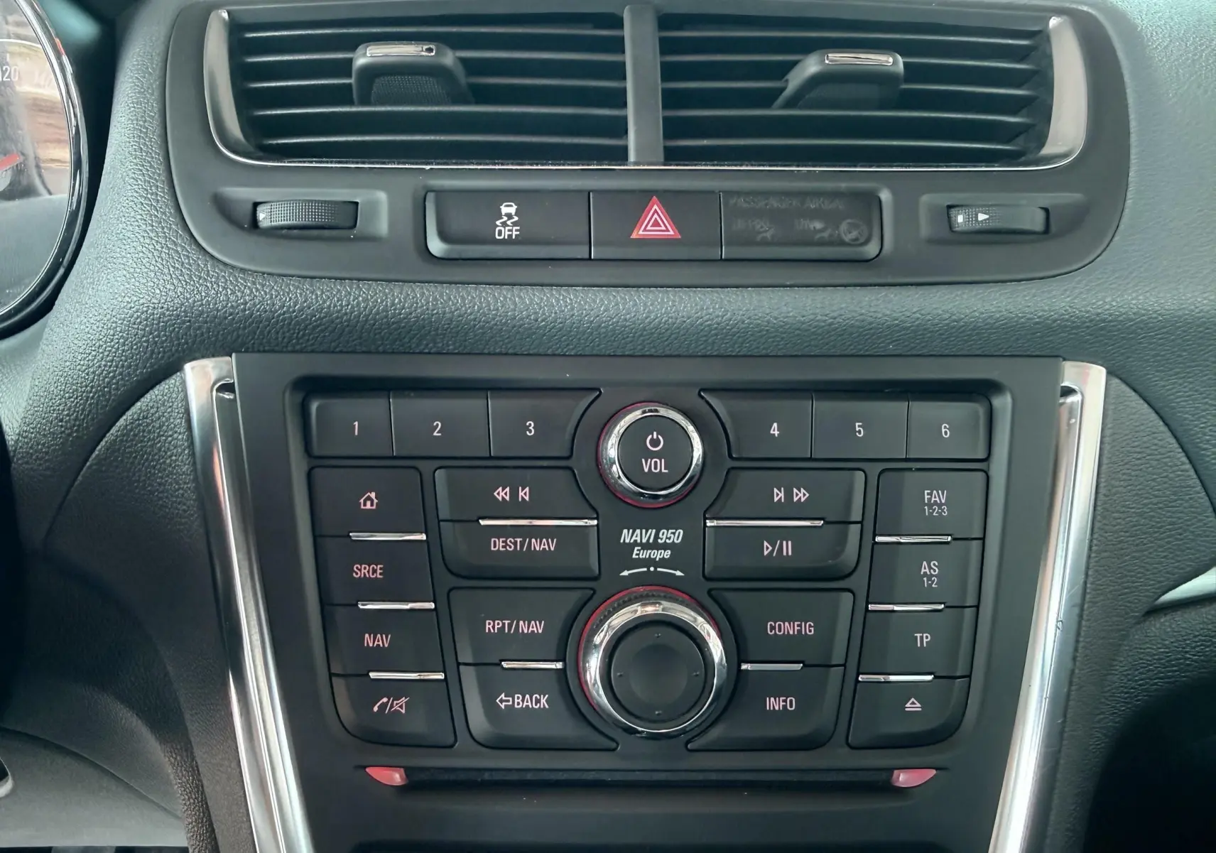 Vue rapprochée du tableau de bord noir de l’Opel Mokka X 2016, mettant en valeur la console centrale avec commandes audio et navigation.