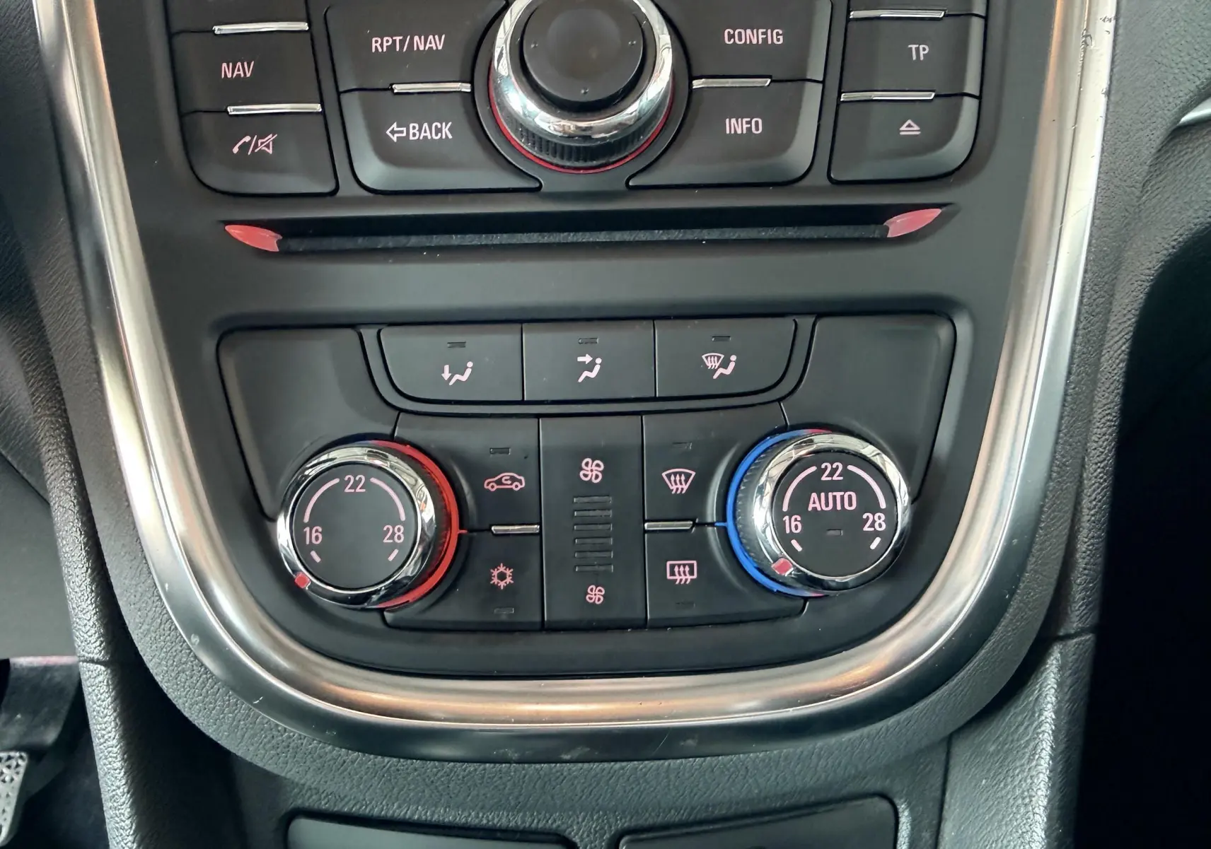 Vue rapprochée de la console centrale de l’Opel Mokka X 2016, avec commandes de climatisation bi-zone et réglages en rouge et bleu.