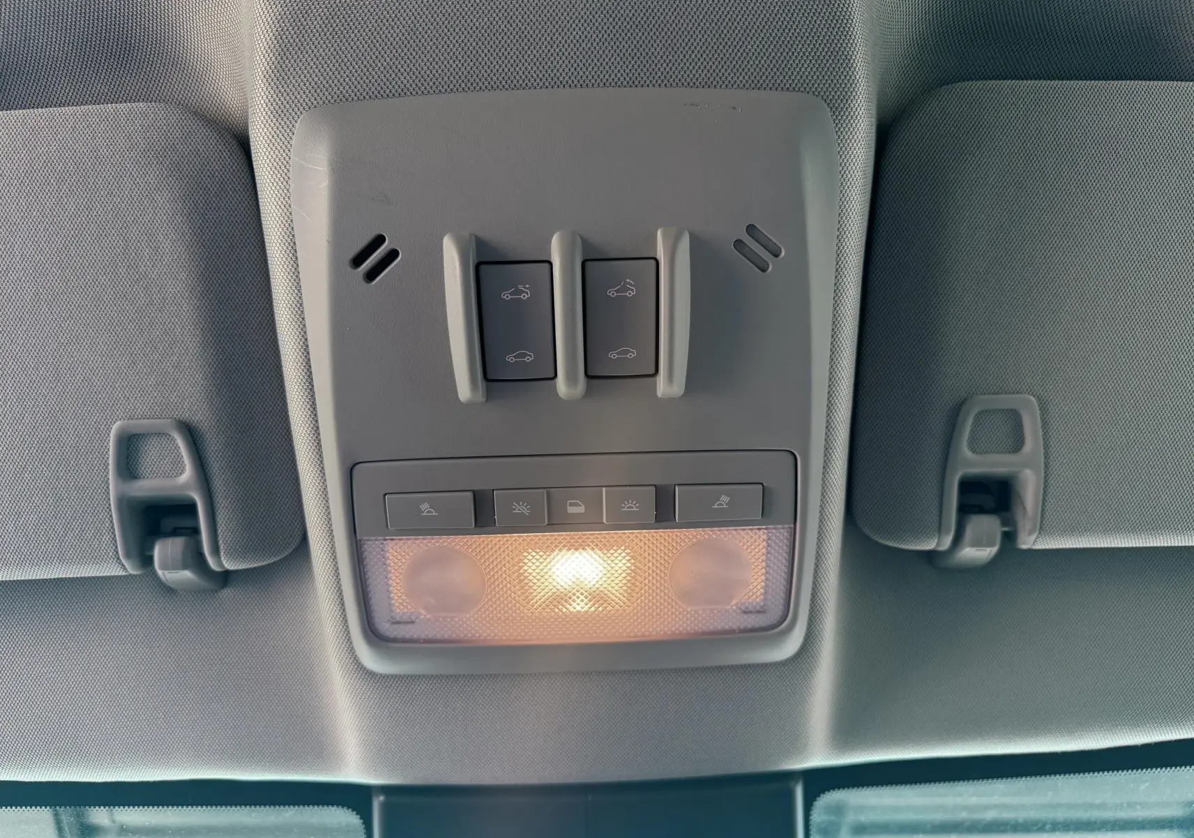 Plafonnier intérieur gris avec commandes d'ouverture de toit ouvrant et éclairage allumé dans un Opel Mokka X 2016.