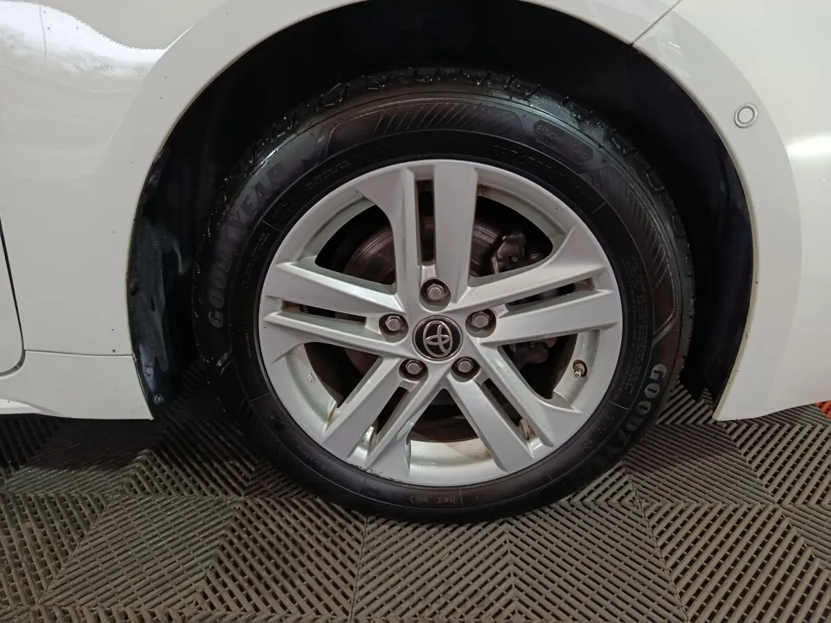 Gros plan sur la roue avant droite blanche d'une Toyota Corolla Hybride 2022 avec jante alliage et pneu Goodyear.