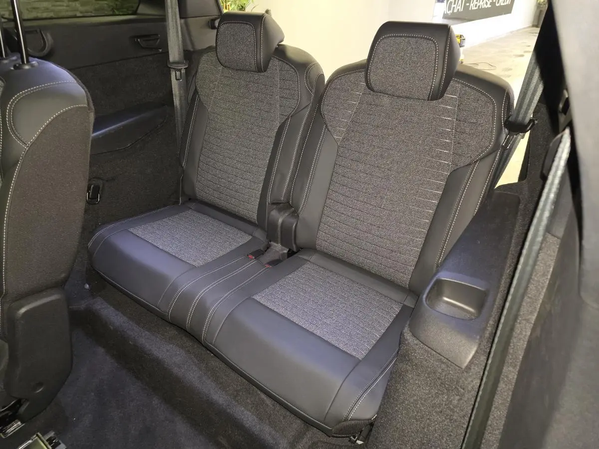 Vue rapprochée de la banquette 2 places arrière du Peugeot 5008 2025, sellerie tissu gris et cuir noir.