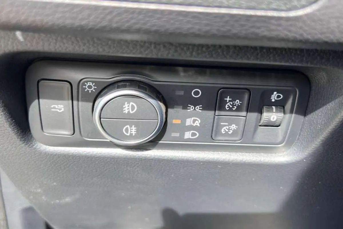 Gros plan sur les commandes d’éclairage et réglage de hauteur des phares du Ford Ranger noir agate 2025.