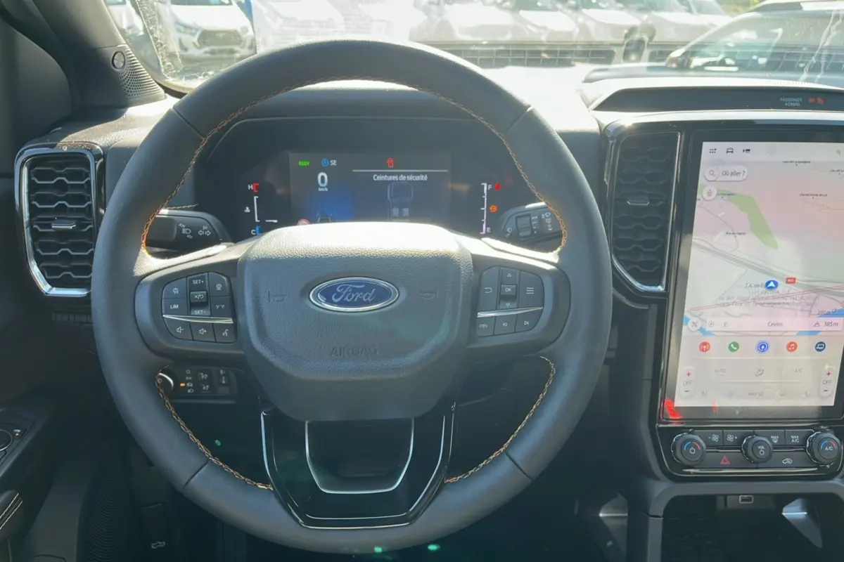 Vue intérieure centrée sur le volant cuir multifonctions et l’écran tactile vertical du Ford Ranger gris carbone 2026.