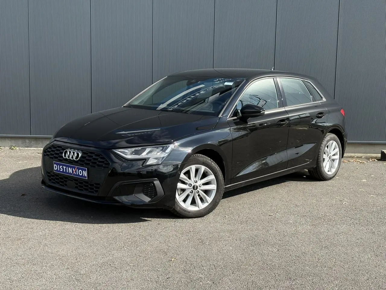Audi A3 Sportback 30 TFSI noir Mythe vue 3/4 avant droit, avec jantes alliage léger et calandre hexagonale noire.
