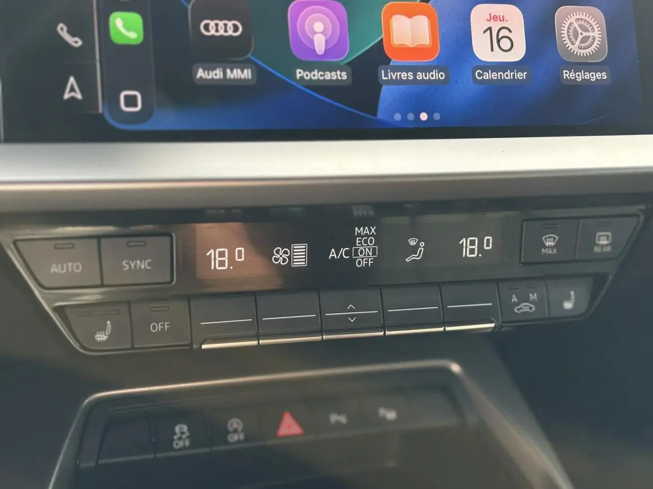 Panneau de climatisation automatique à deux zones de l'Audi A3 Sportback 30 TFSI noir, avec réglages affichés à 18 degrés.