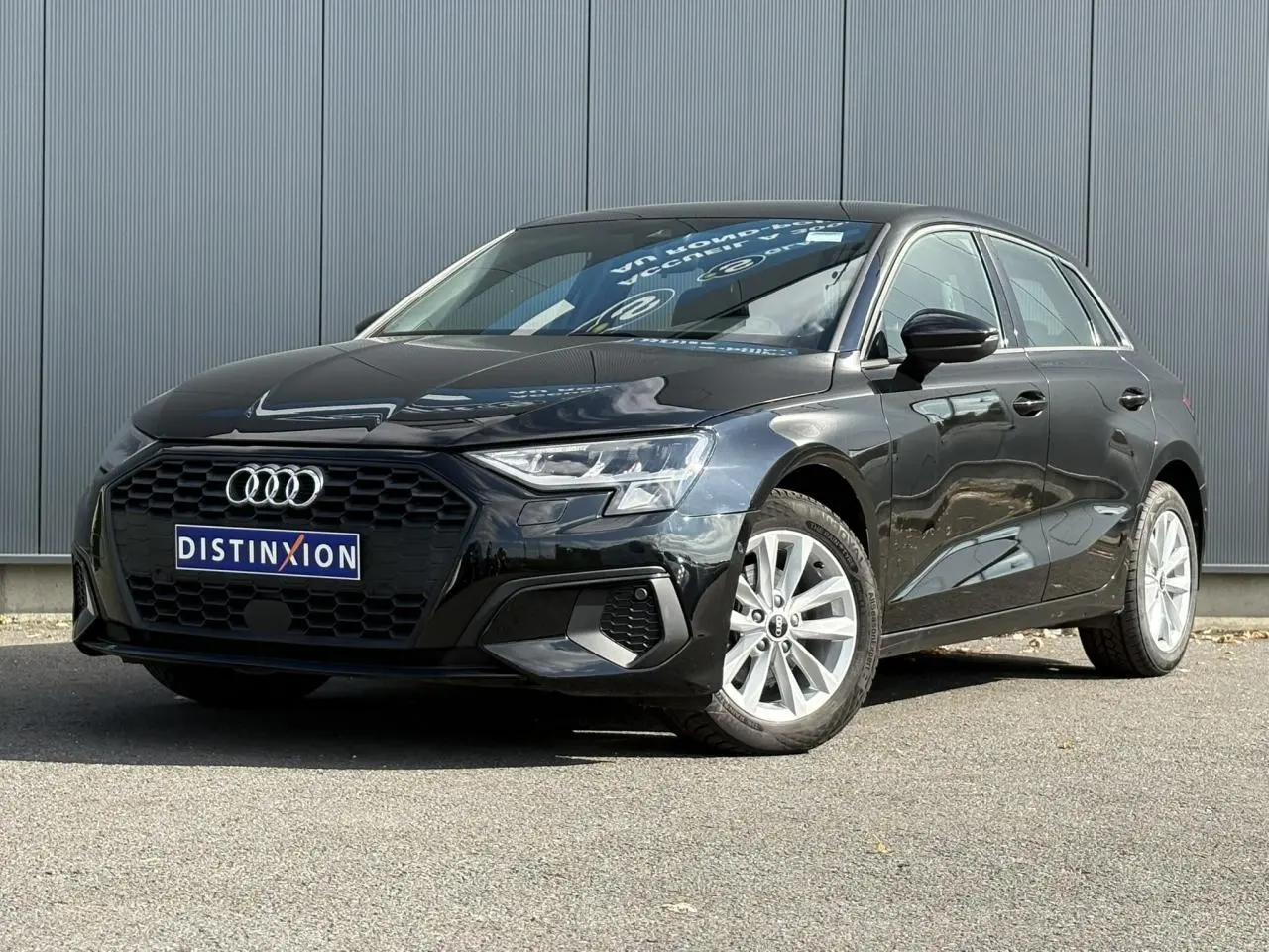 Audi A3 Sportback noir Mythe vue 3/4 avant droit avec calandre hexagonale et jantes alliage 16 pouces.
