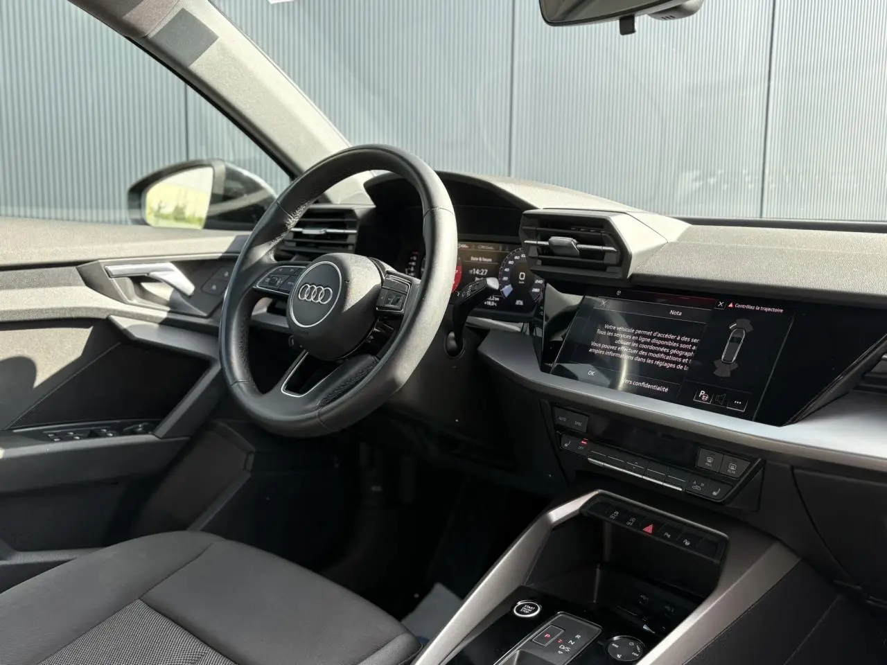 Vue intérieure côté conducteur de l'Audi A3 Sportback 2023 avec tableau de bord numérique et écran tactile central.