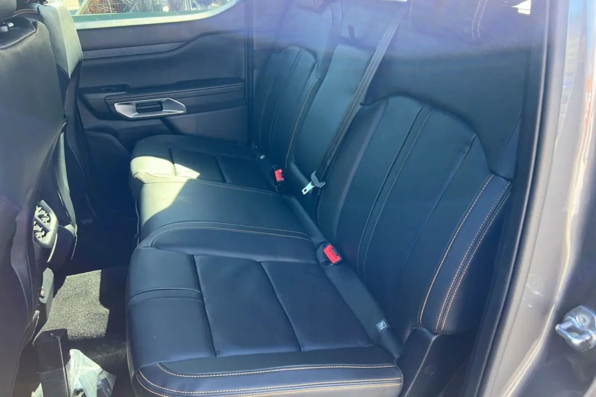 Vue intérieure côté droit des sièges arrière en cuir noir avec surpiqûres contrastantes du Ford Ranger Wildtrak Plus gris carbone.