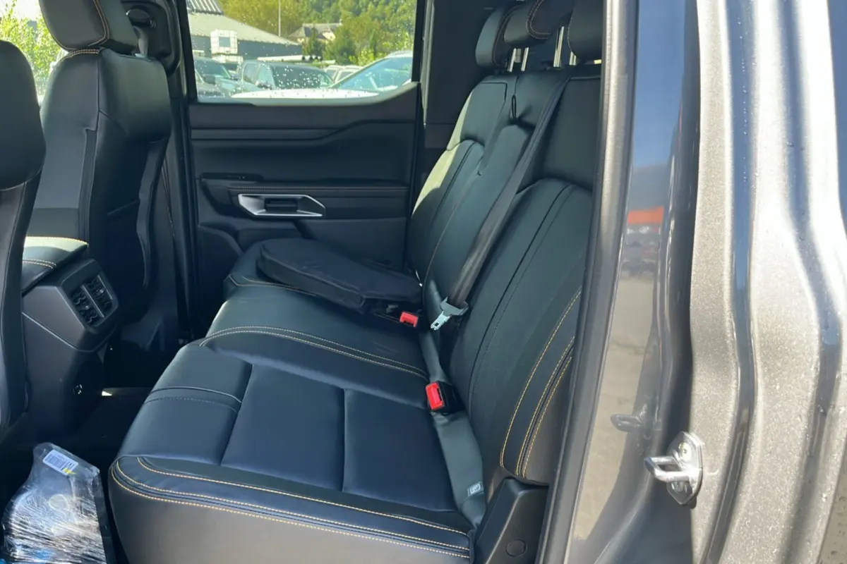 Vue intérieure côté droit sur la banquette arrière en cuir noir avec surpiqûres jaunes du Ford Ranger gris carbone.
