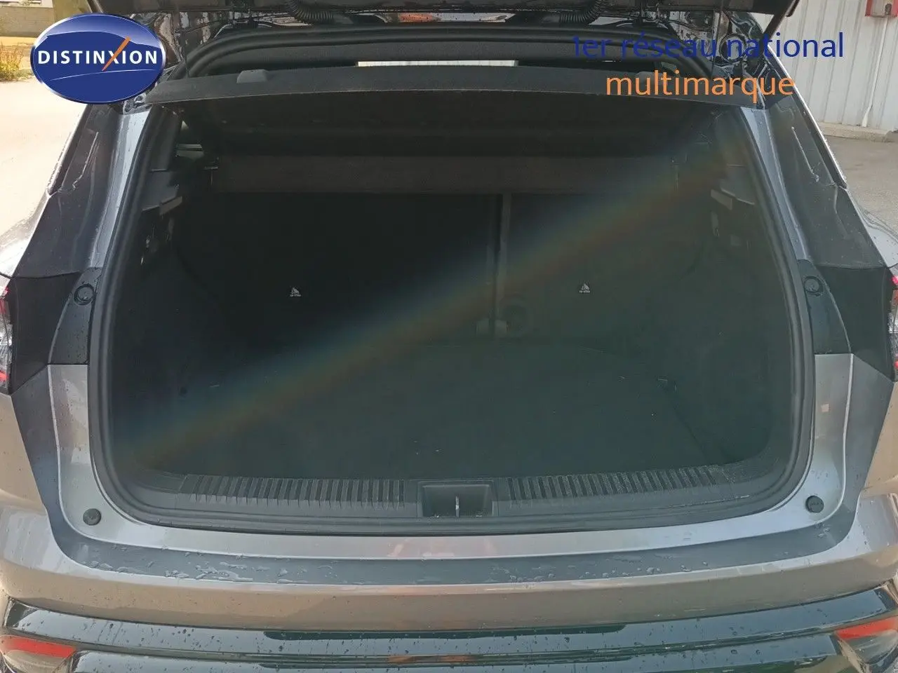 Coffre ouvert d’un Renault Austral gris schiste métal, vue arrière montrant l’espace de chargement vide.