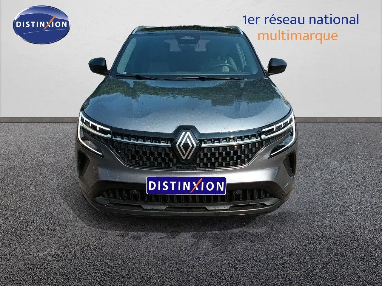 Vue avant d'un Renault Austral gris schiste métal avec calandre noire et logo Renault central bien visible.