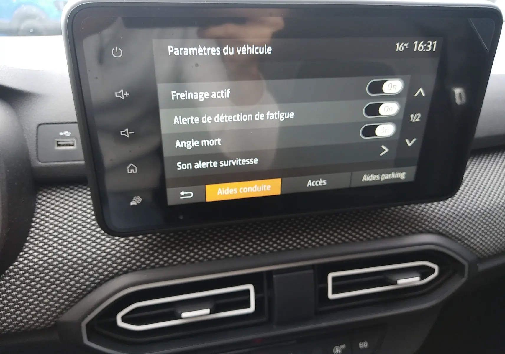 Écran tactile central intérieur de la Dacia Sandero gris 2024 affichant les paramètres d’aides à la conduite.