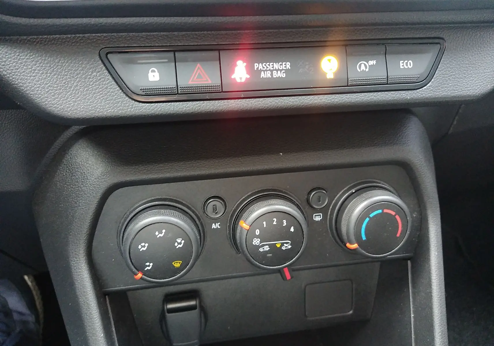 Gros plan sur les commandes de climatisation et les voyants du tableau de bord d’une Dacia Sandero gris 2024.
