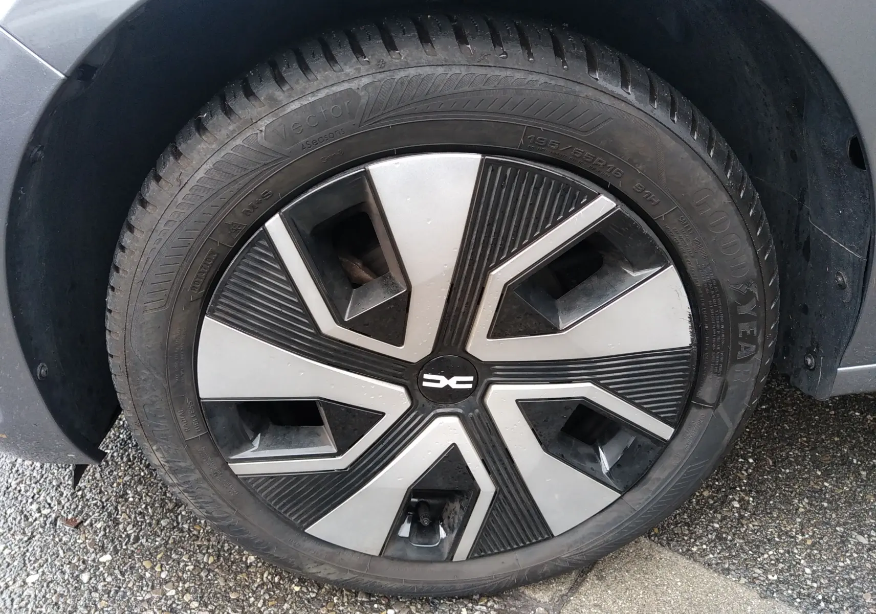 Gros plan sur la roue avant gauche d'une Dacia Sandero gris 2024, mettant en valeur la jante au design moderne bicolore.
