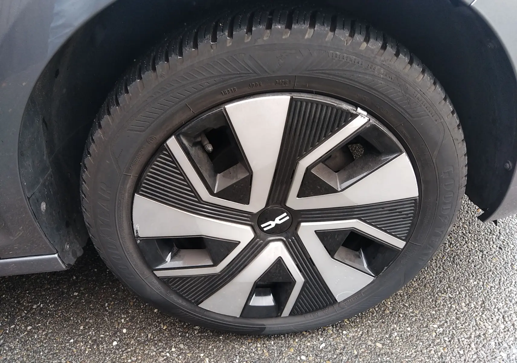 Gros plan sur la roue avant gauche gris métallisé de la Dacia Sandero 2024 avec jante au design géométrique noir et argent.