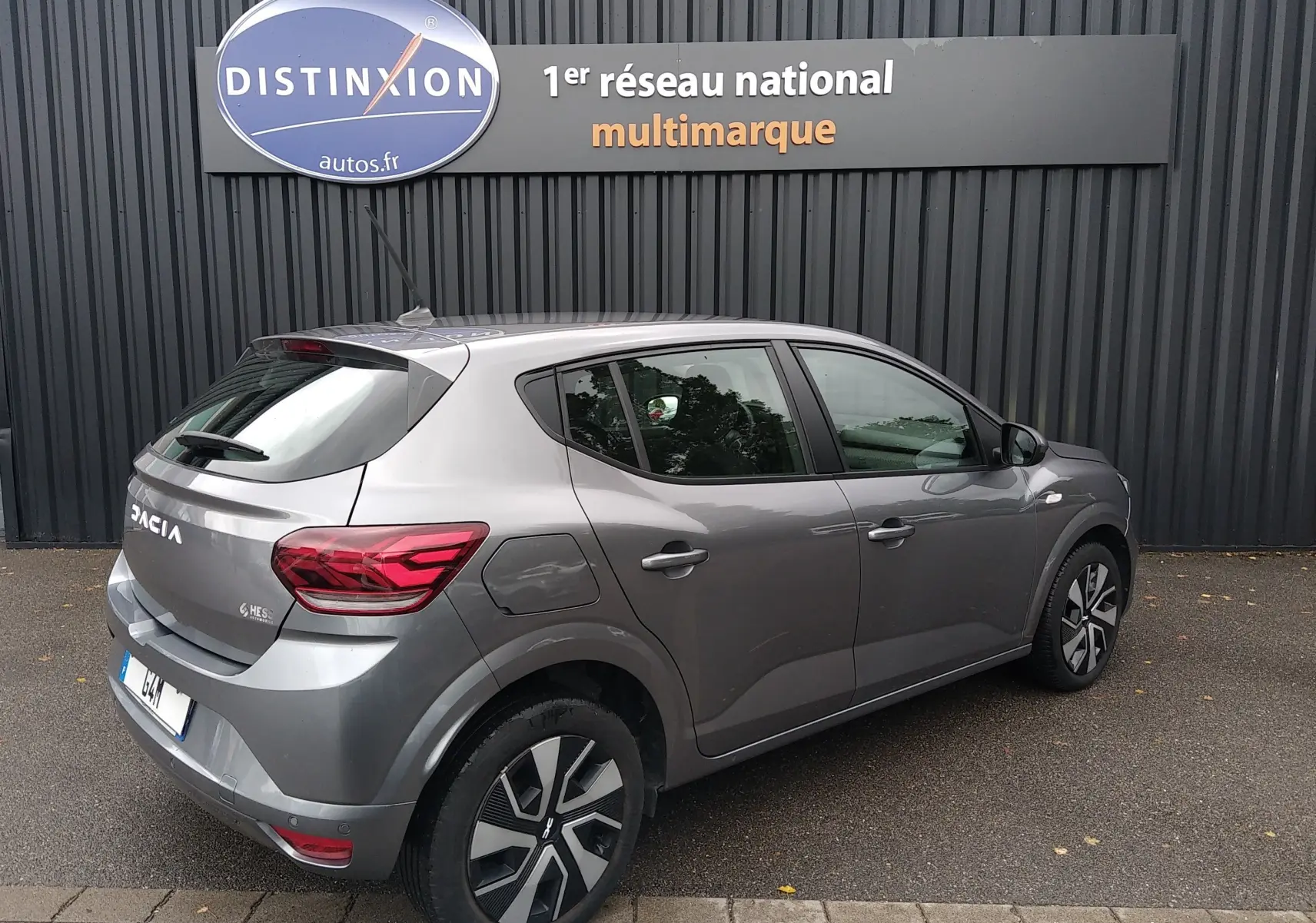 Vue 3/4 arrière droite d'une Dacia Sandero gris 2024, compacte cinq portes avec feux arrière LED et jantes stylisées.
