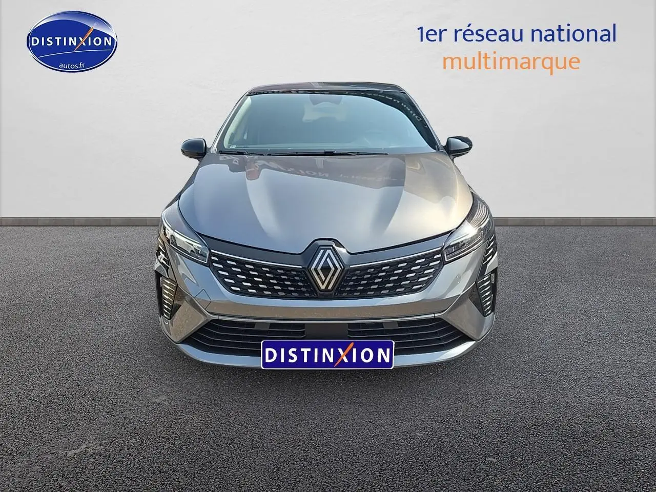 Vue frontale d'une Renault Clio V gris schiste avec calandre chromée et phares LED allumés.