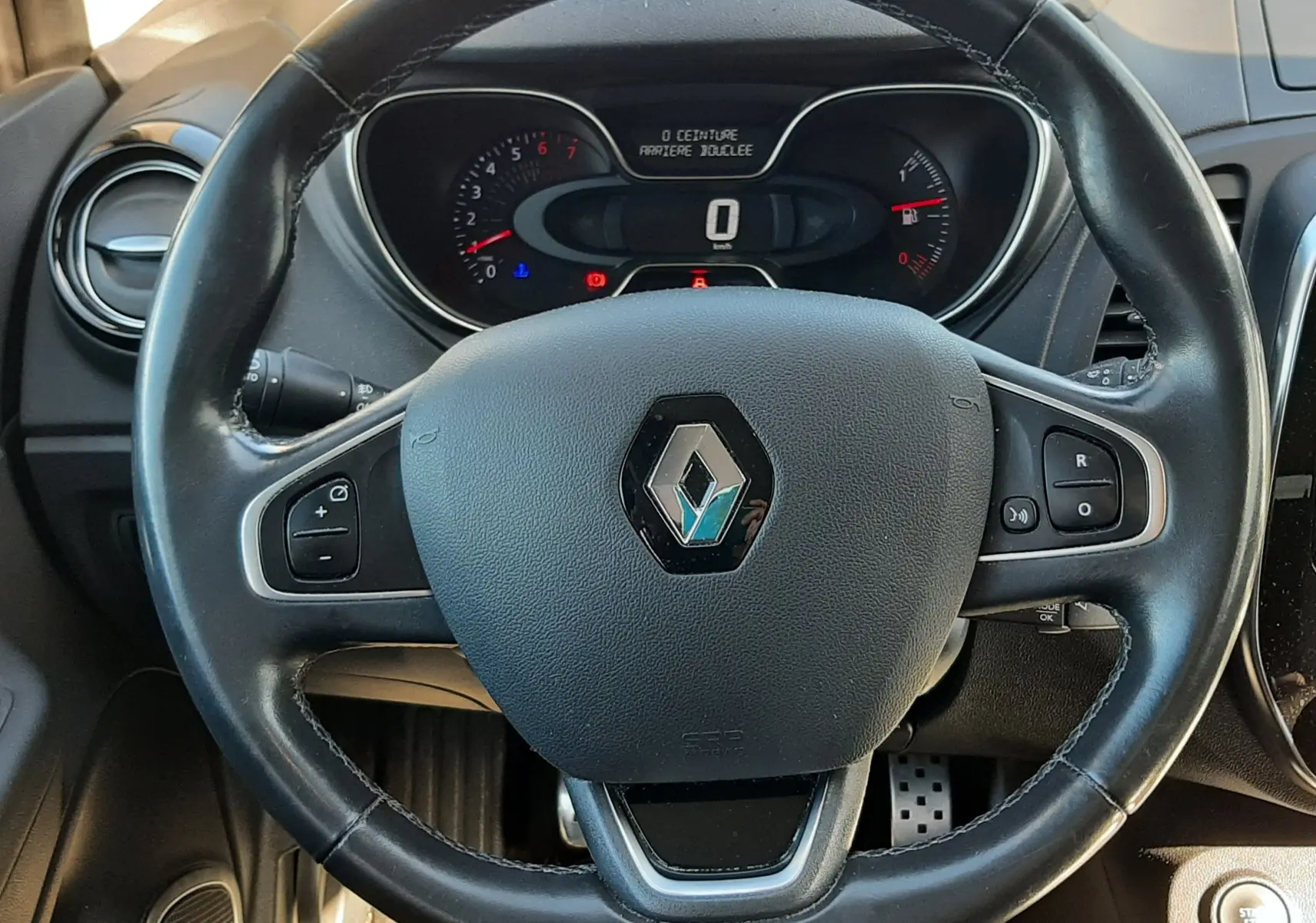 Vue rapprochée du volant cuir noir du Renault Captur 2018, avec commandes intégrées et tableau de bord partiel visible.