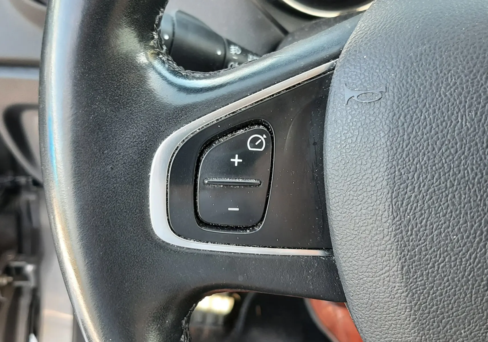 Gros plan sur le volant noir du Renault Captur 2018, montrant les commandes de réglage d'éclairage côté gauche.
