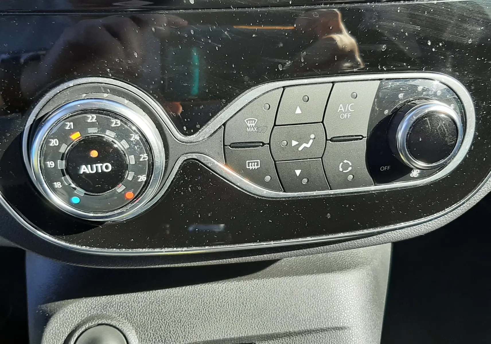 Gros plan sur la console centrale du Renault Captur gris cassiope avec commandes de climatisation et bouton start/stop.