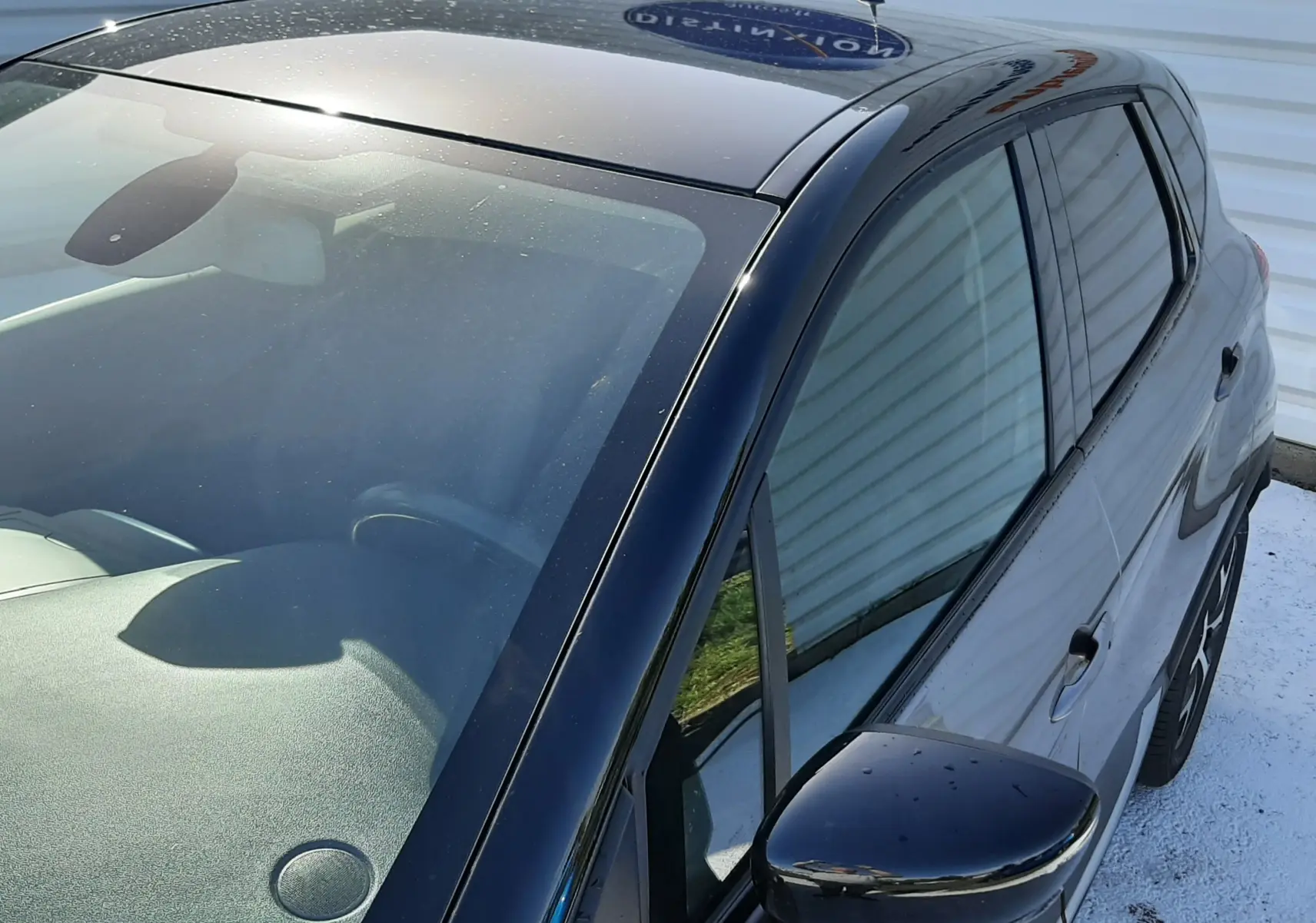 Vue 3/4 avant droit du Renault Captur gris Cassiope avec toit noir brillant et rétroviseur droit noir.