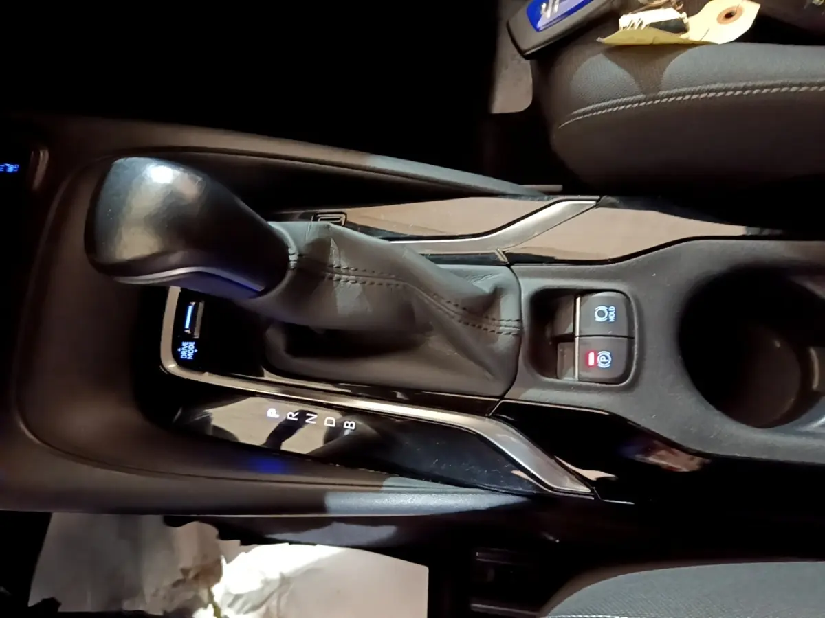 Gros plan sur la console centrale avec levier de vitesses automatique en cuir noir du Suzuki Swace gris clair.