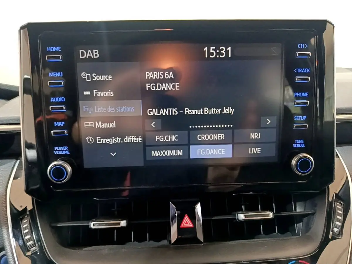 Écran tactile central du tableau de bord du Suzuki Swace 1.8 Hybrid Privilege, affichant les stations radio DAB.