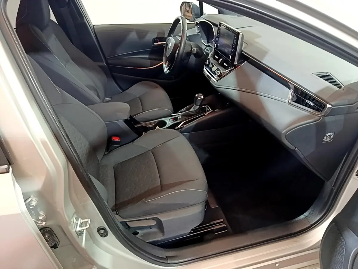 Intérieur avant droit d'une Suzuki Swace gris clair, montrant sièges tissu et tableau de bord avec écran tactile.