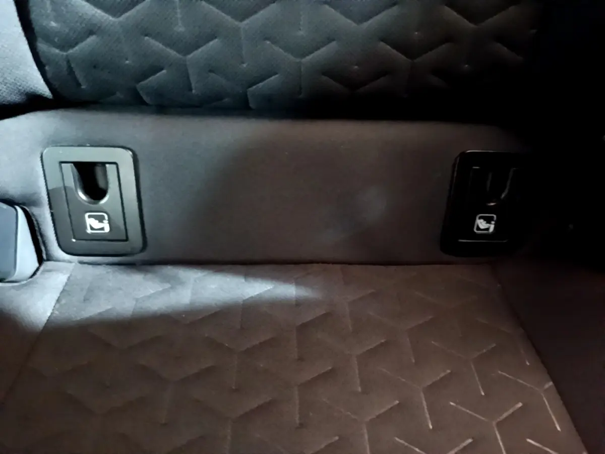 Détail des attaches Isofix sur la banquette arrière en tissu gris foncé du Suzuki Swace 1.8 Hybrid Privilege.