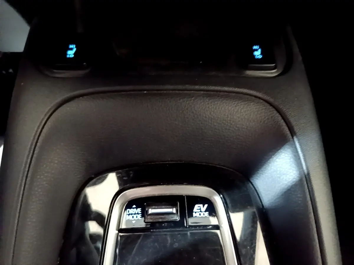 Vue rapprochée du sélecteur de modes de conduite sur la console centrale noire du Suzuki Swace gris clair hybride.