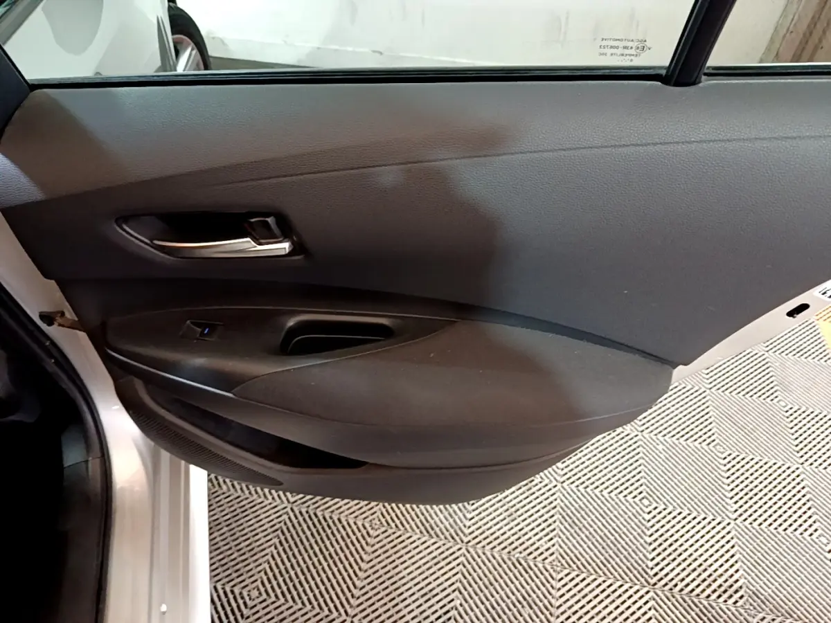 Gros plan sur la porte intérieure côté gauche du Suzuki Swace 1.8 Hybrid Privilege avec garniture noire et poignée argentée.