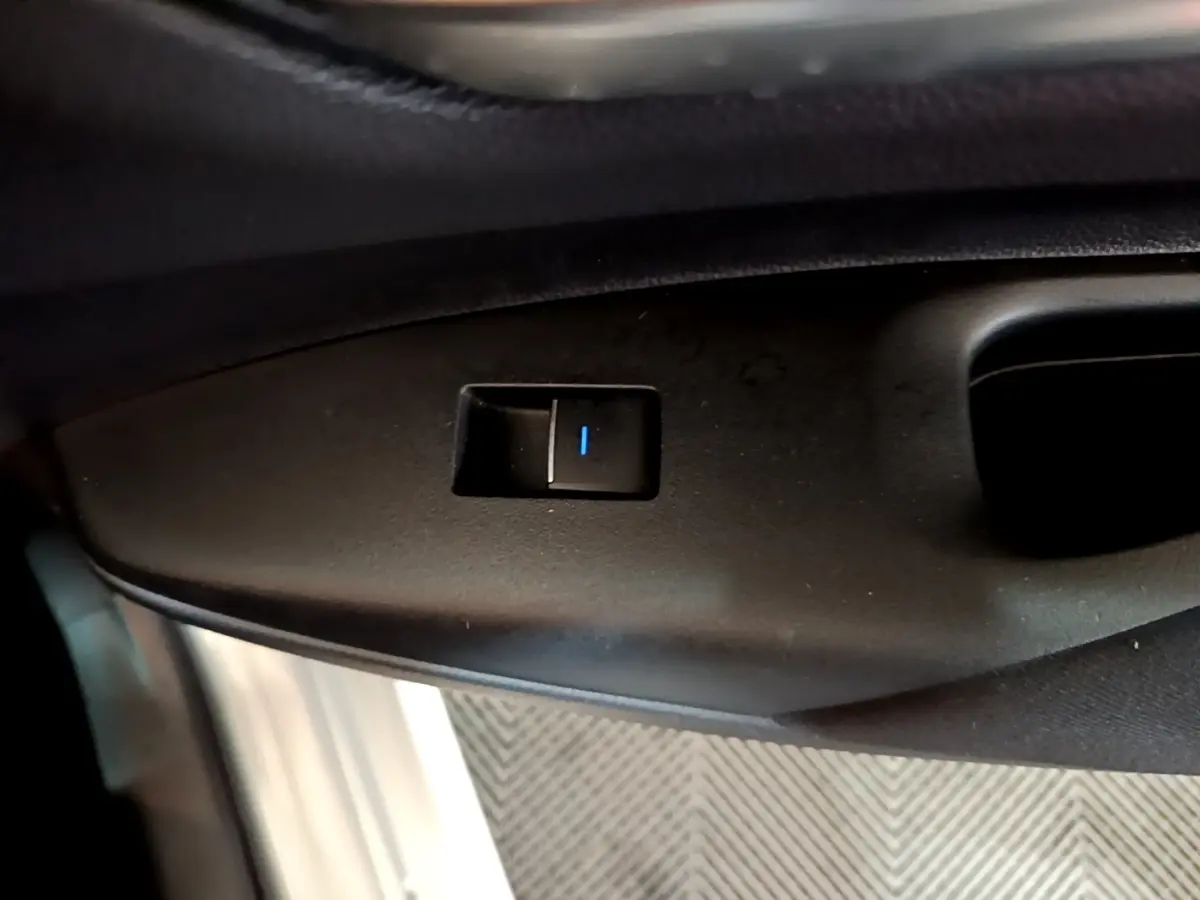 Bouton de commande de verrouillage sur la portière côté conducteur d'une Suzuki Swace gris clair 1.8 Hybrid Privilege.