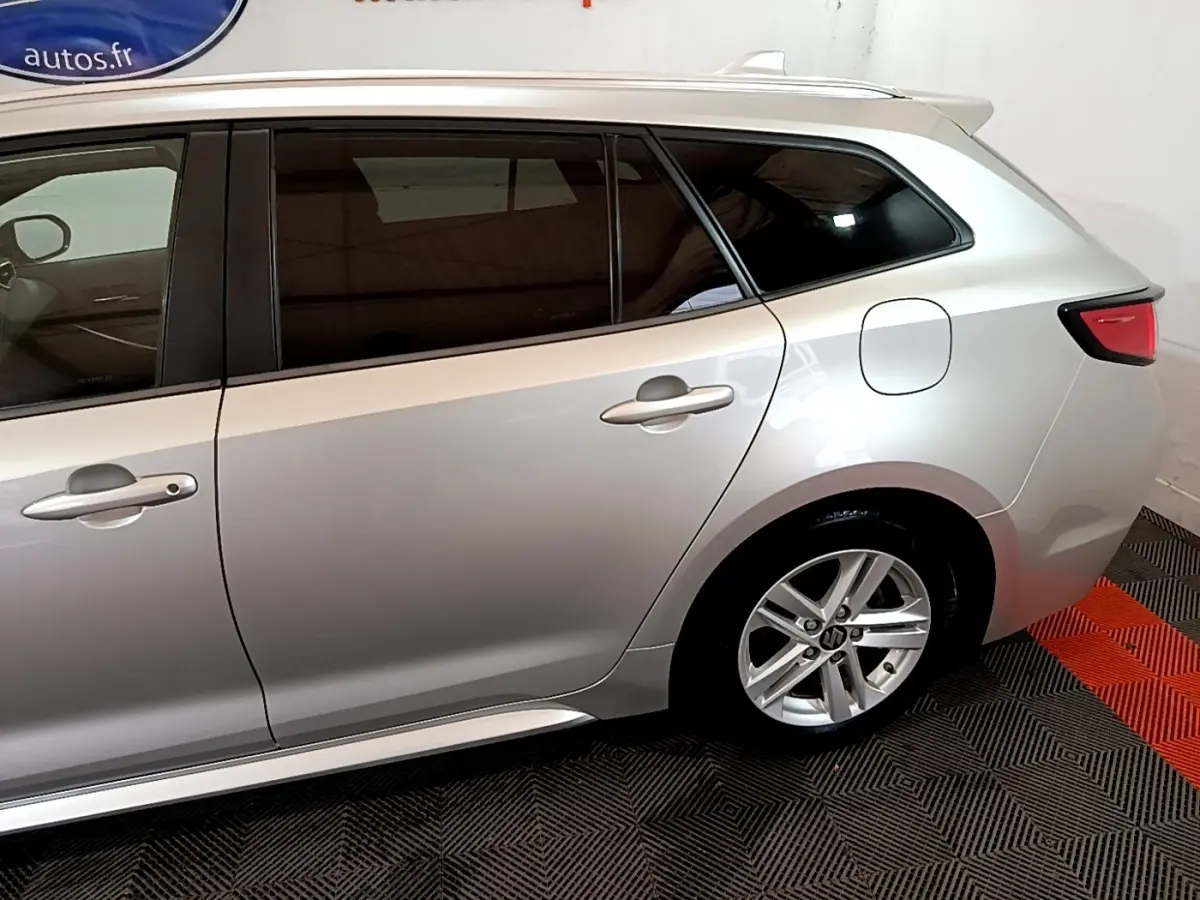 Vue latérale droite sur l'arrière d'une Suzuki Swace gris clair avec jante alliage et vitres teintées.