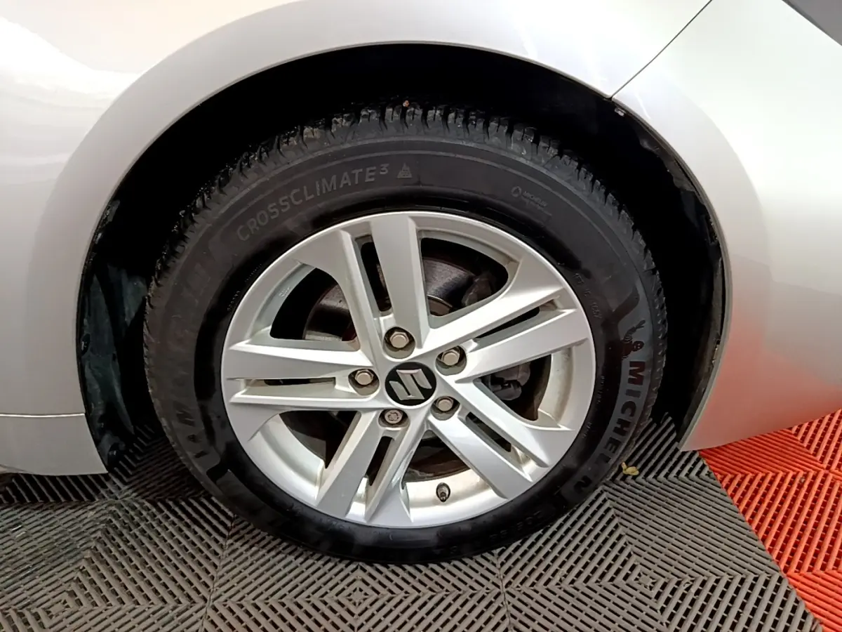 Gros plan sur la roue arrière droite d'une Suzuki Swace 1.8 Hybrid Privilege gris clair, avec pneu Michelin visible.