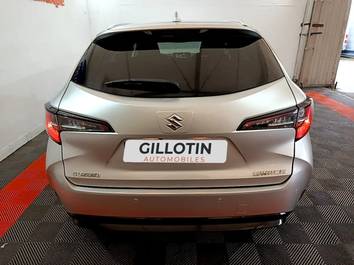 Vue arrière d'une Suzuki Swace gris clair 2021 avec feux arrière LED et logo Suzuki visible.