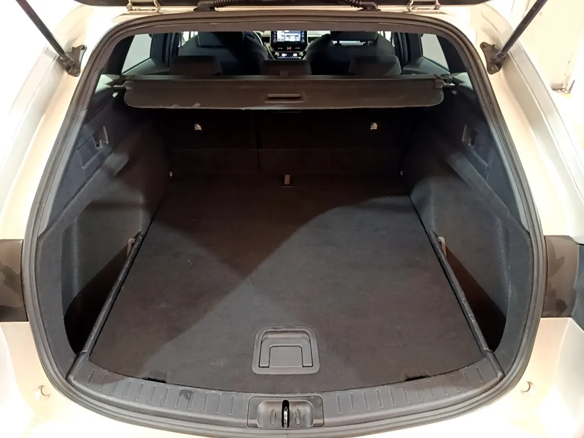 Coffre ouvert vu de l'arrière d'une Suzuki Swace gris clair, montrant l'espace de chargement et l'intérieur sombre.