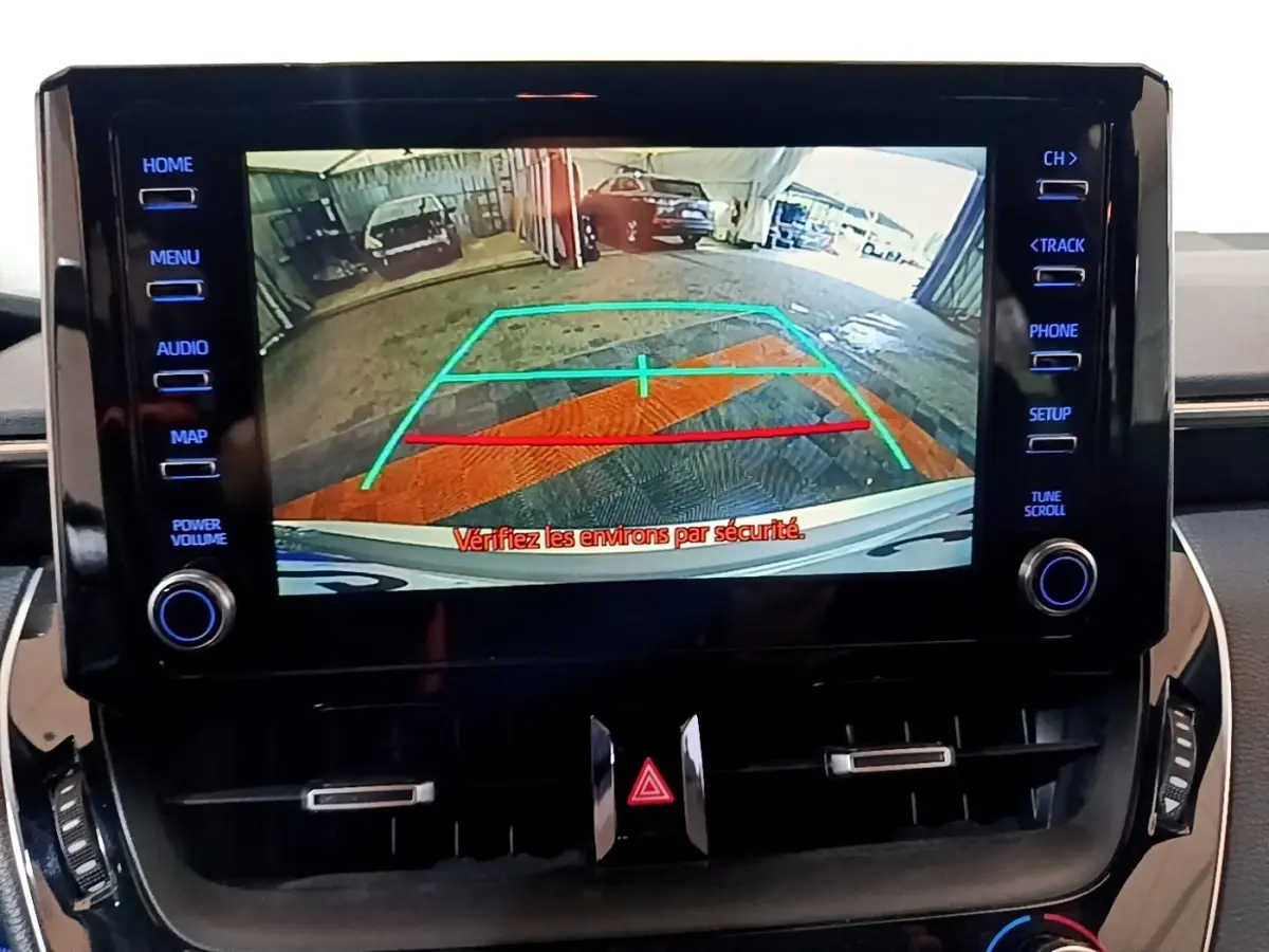 Écran tactile central montrant la caméra de recul avec lignes de guidage dans un Suzuki Swace gris clair.
