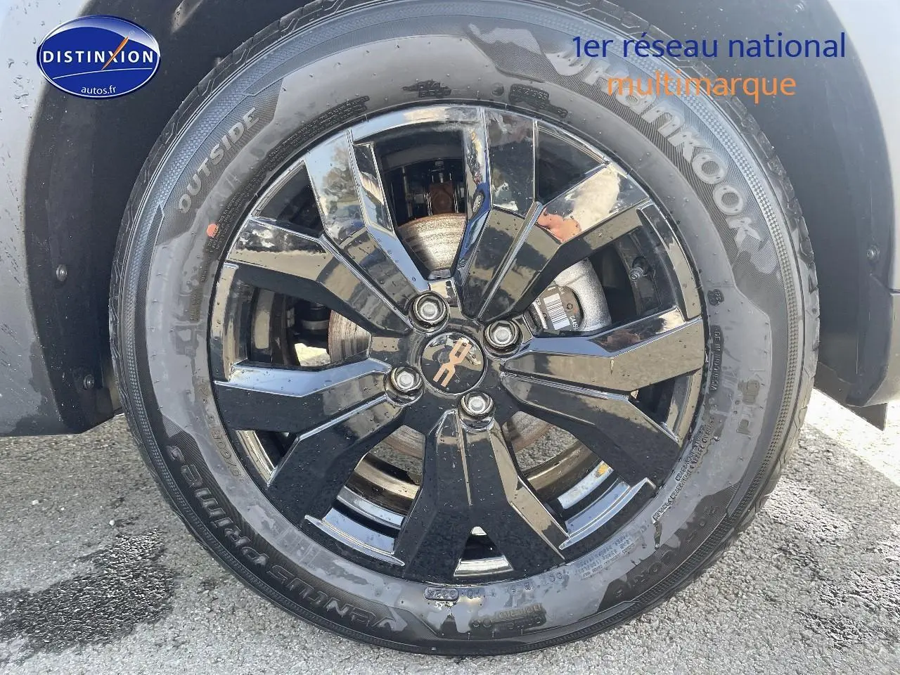 Gros plan sur la jante noire brillante et le pneu Hankook d'une Dacia Sandero Stepway gris schiste.