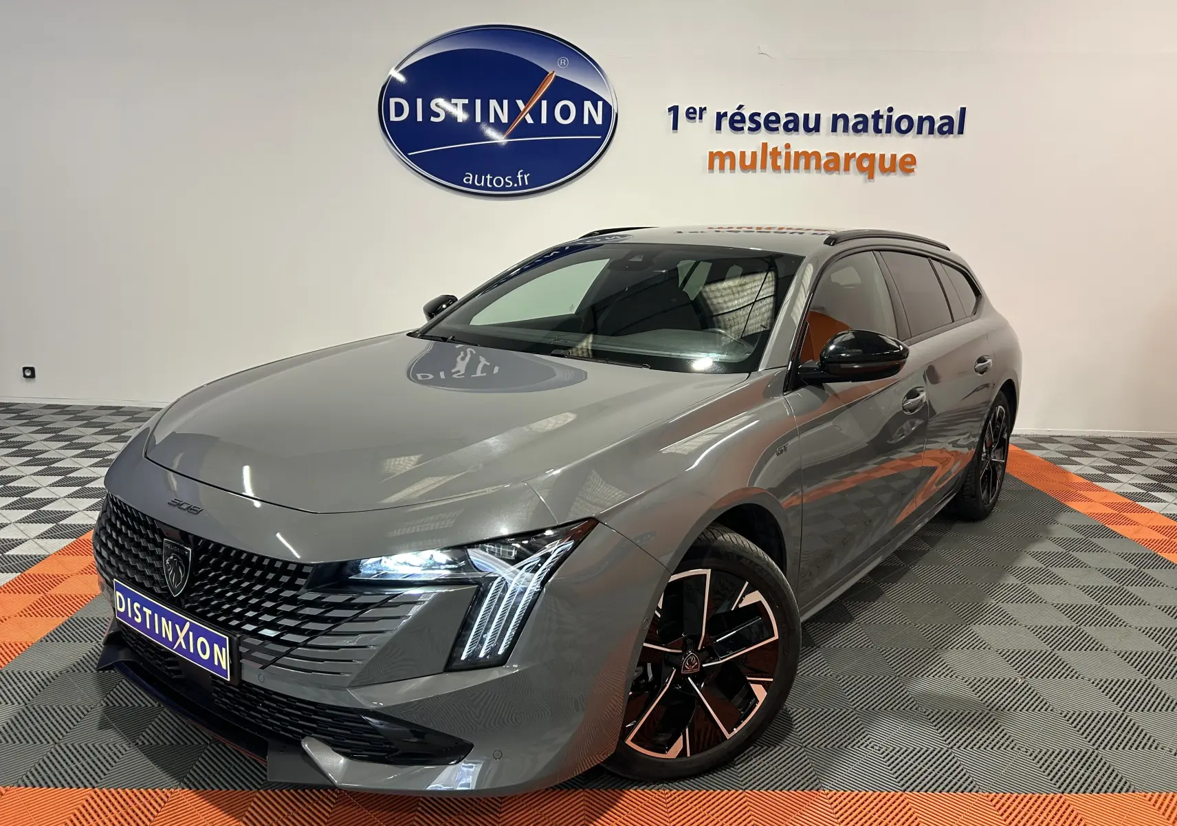 Peugeot 508 SW gris Selenium vue 3/4 avant droit avec phares LED allumés et jantes noires bicolores.