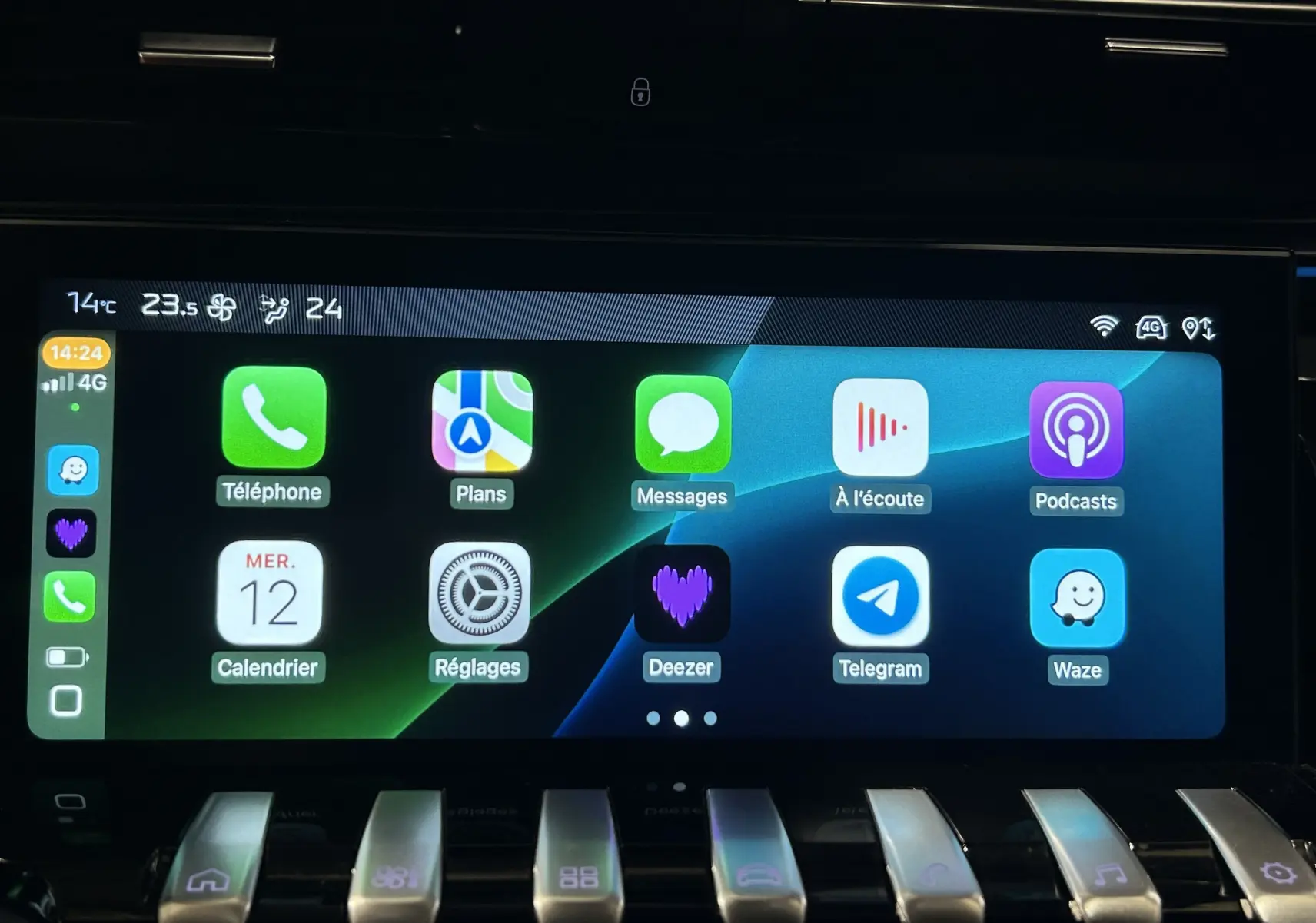 Écran tactile central de la Peugeot 508 SW 2024 affichant les applications connectées, avec commandes piano en dessous.