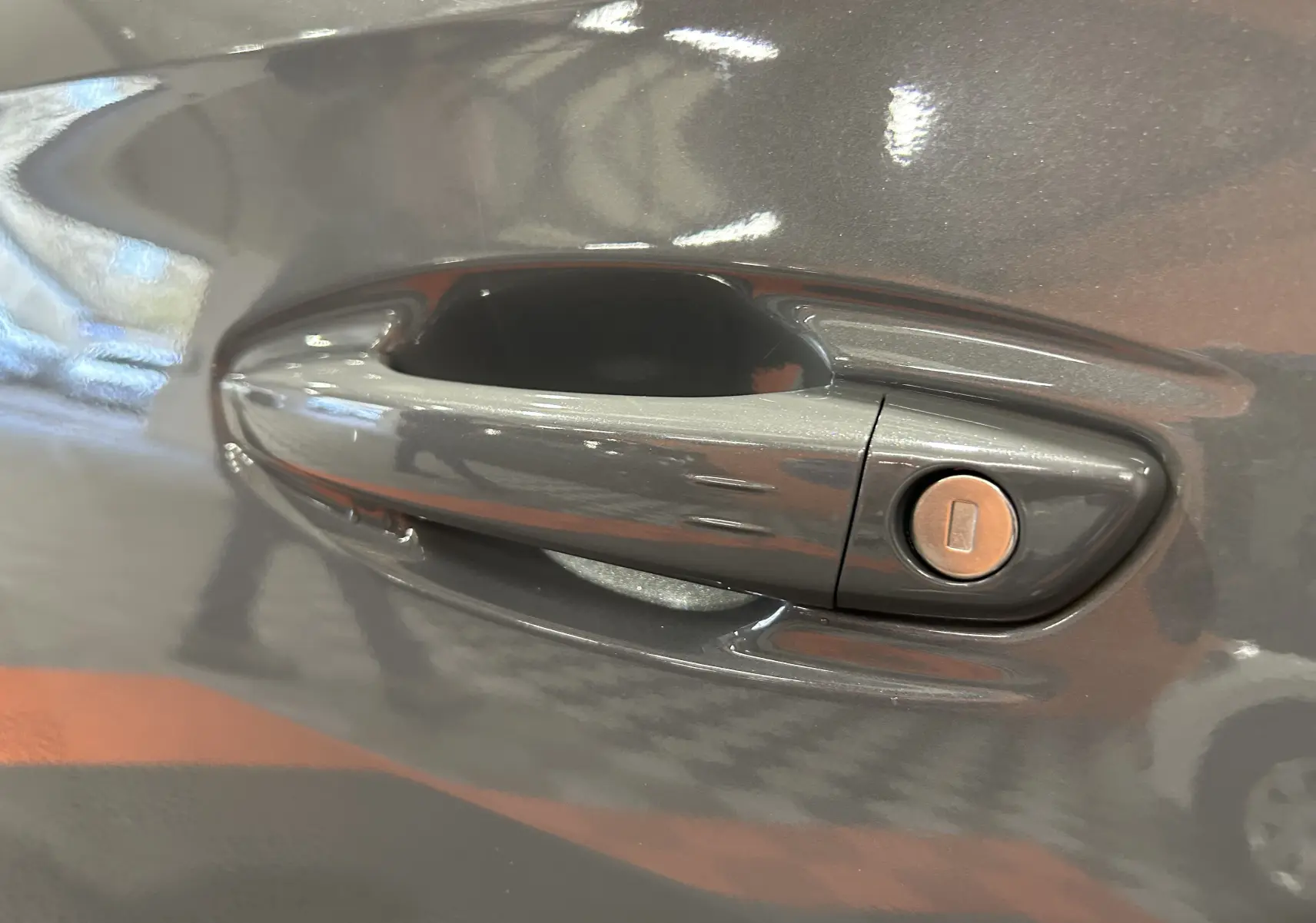 Poignée de porte avant droite gris Selenium de la Peugeot 508 SW 2024 avec serrure intégrée visible.