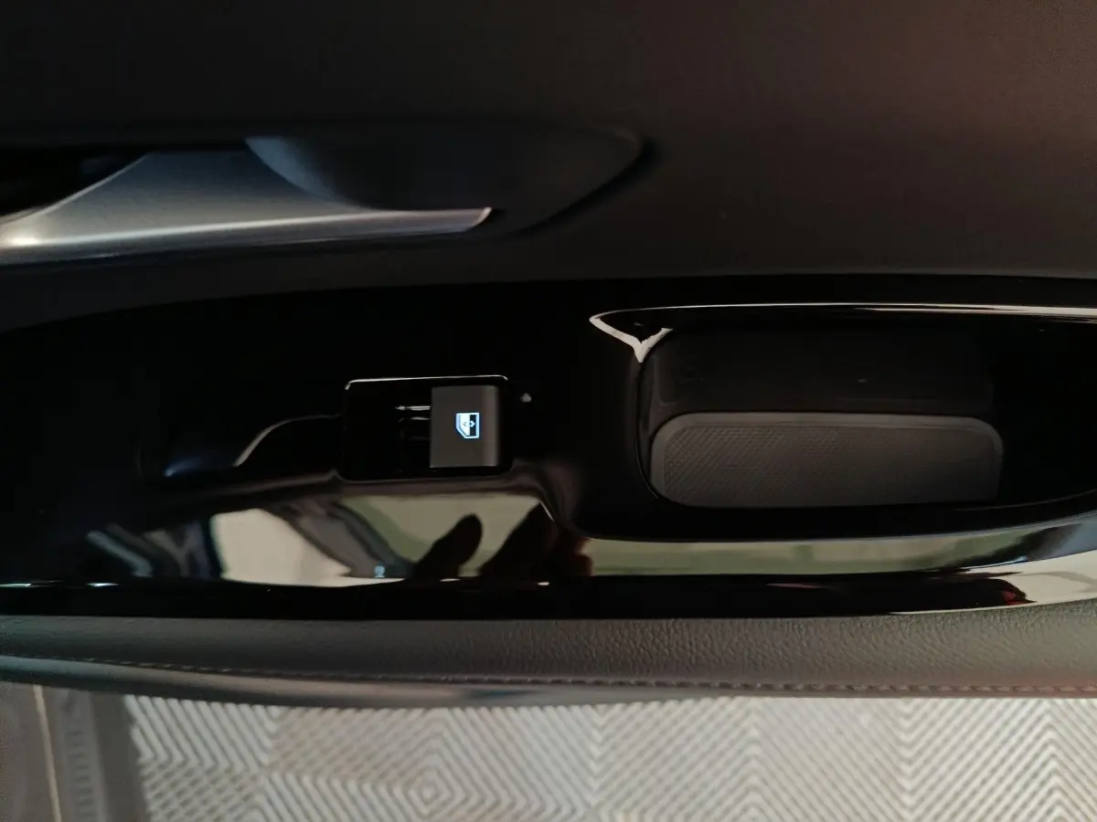 Gros plan sur la commande de lève-vitre électrique côté conducteur du Hyundai Tucson gris clair 2025.